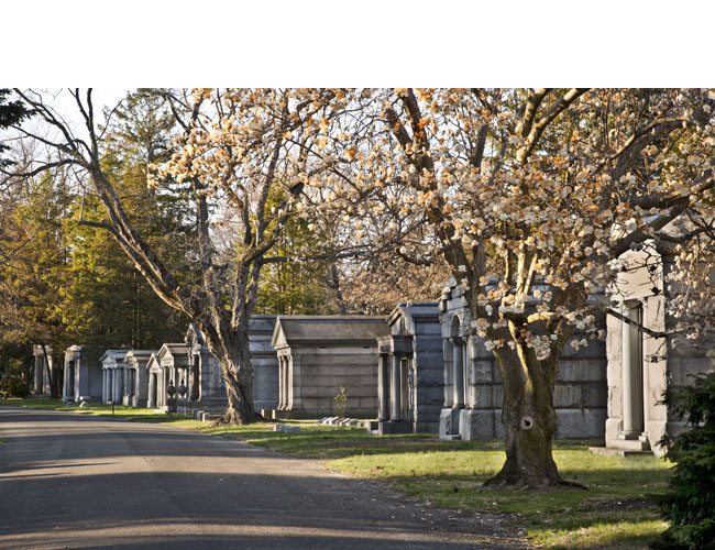Park Avenue lined with modestly-scaled mausoleums set close together on small lots. Photograph by Gavin Ashworth. Courtesy The Woodlawn Cemetery. Park Avenue Mausoleums